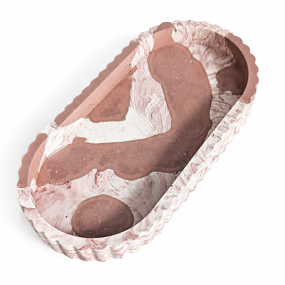 An oval decorative tray with a scalloped rim, featuring a pink and white marble pattern, shown on a plain white background.